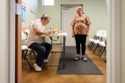 Volunteer Eddie Garcia, left, takes down prescription information for Sanjuana Dominguez at a medical clinic provided free of charge to local residents in Hope, Ark. on Sept. 7, 2023. Photo by Rory Doyle.